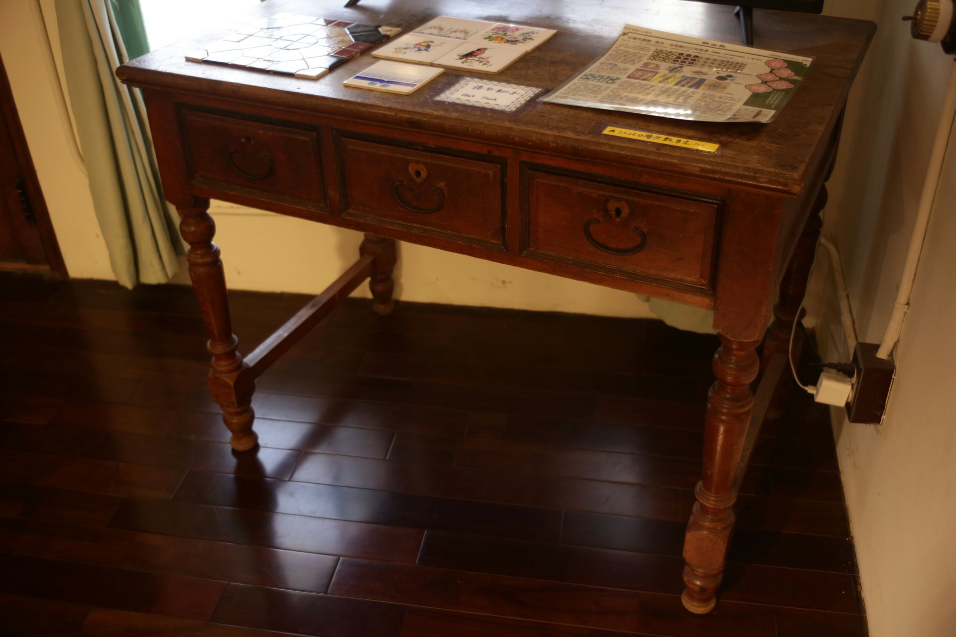 Antique wooden desk with three drawers and ornate legs