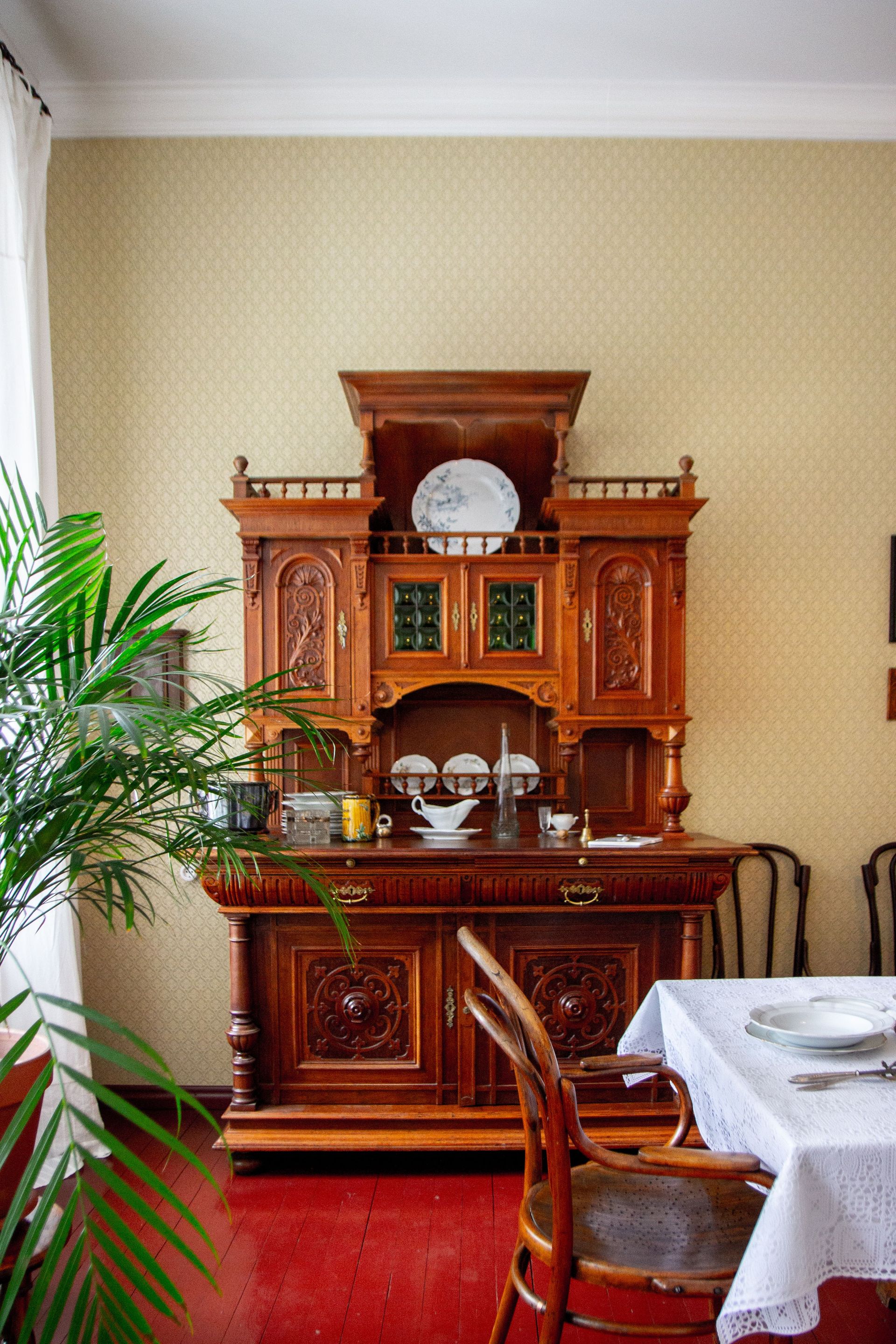 Classic interior design featuring a vintage wooden cabinet and dining table setting.